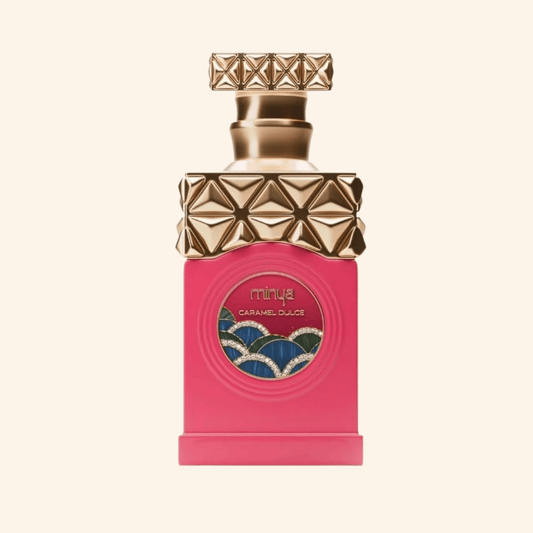 Perfume bottle with gold cap and pink base on a beige background. Discover Paris Corner Minya Caramel Dulce UK. A fun, decadent gourmand EDP with popcorn, butter, chestnut, chocolate & caramel. The ultimate cosy treat. Shop now!
