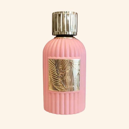 Pink perfume bottle with gold cap on a white background. Discover Paris Corner Qissa Pink UK. A chic women's EDP with apple, coconut, rose, violet & a woody vanilla base. Avent-us for Her alternative. Shop now!