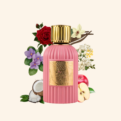 Pink perfume bottle with gold cap surrounded by flowers and fruits on a white background. Discover Paris Corner Qissa Pink UK. A chic women's EDP with apple, coconut, rose, violet & a woody vanilla base. Avent-us for Her alternative. Shop now!